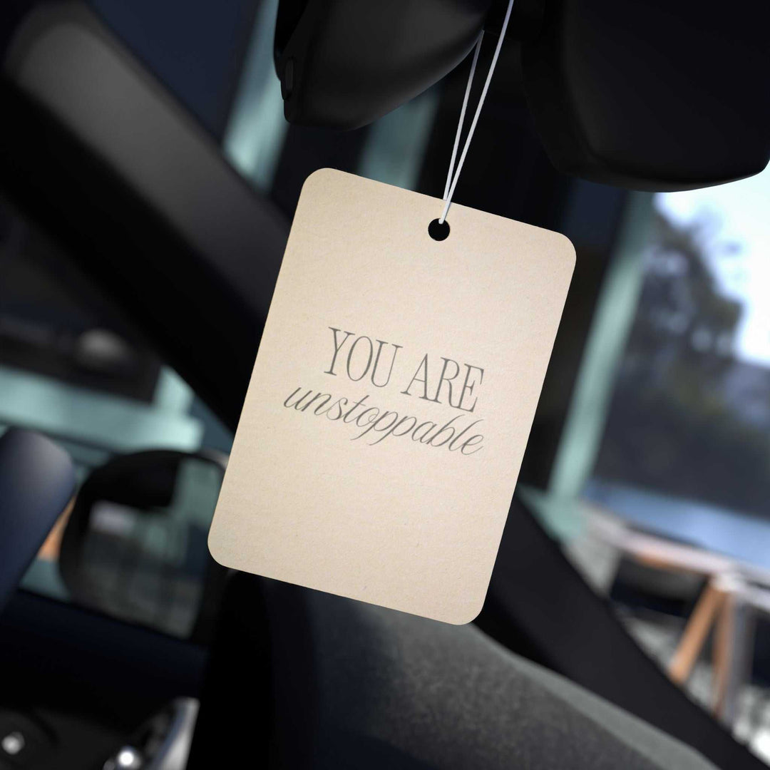 Car air freshener with "You Are Unstoppable" message in a car interior