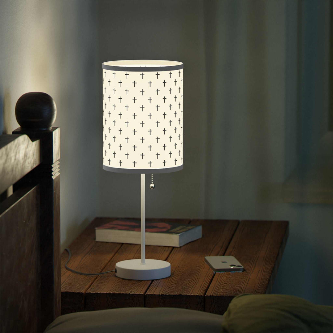 Jesus Cross Lamp with steel base and printed shade featuring multiple crosses on wooden bedside table