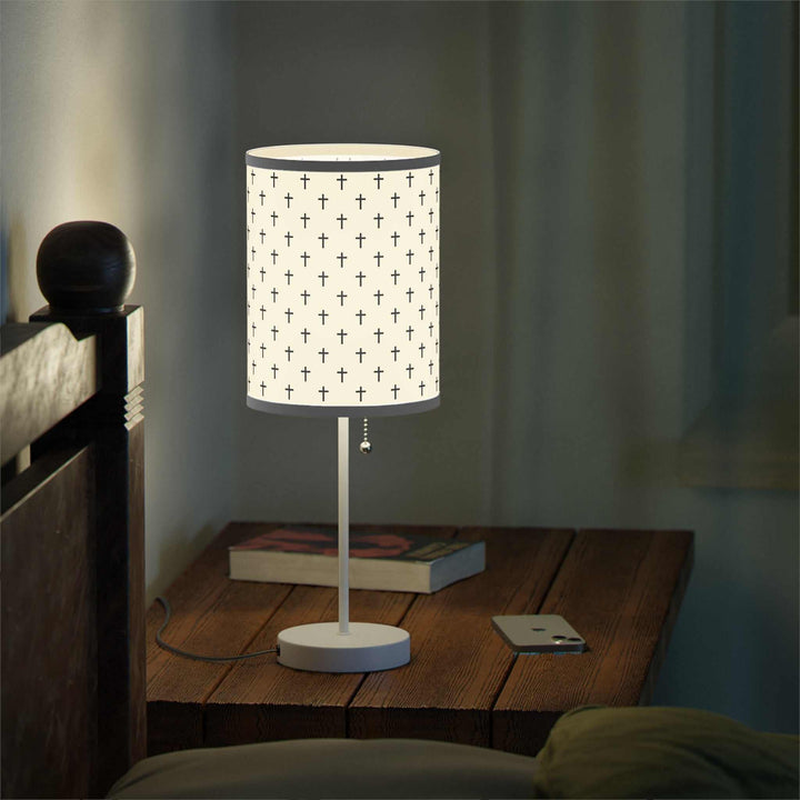 Jesus Cross Lamp with steel base and printed shade featuring multiple crosses on wooden bedside table