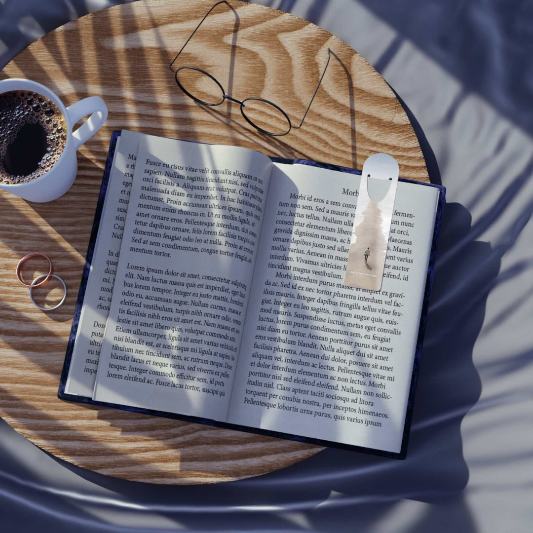 Walk by Faith Bookmark aluminum page holder with top slot on open book on wooden table with coffee cup and glasses