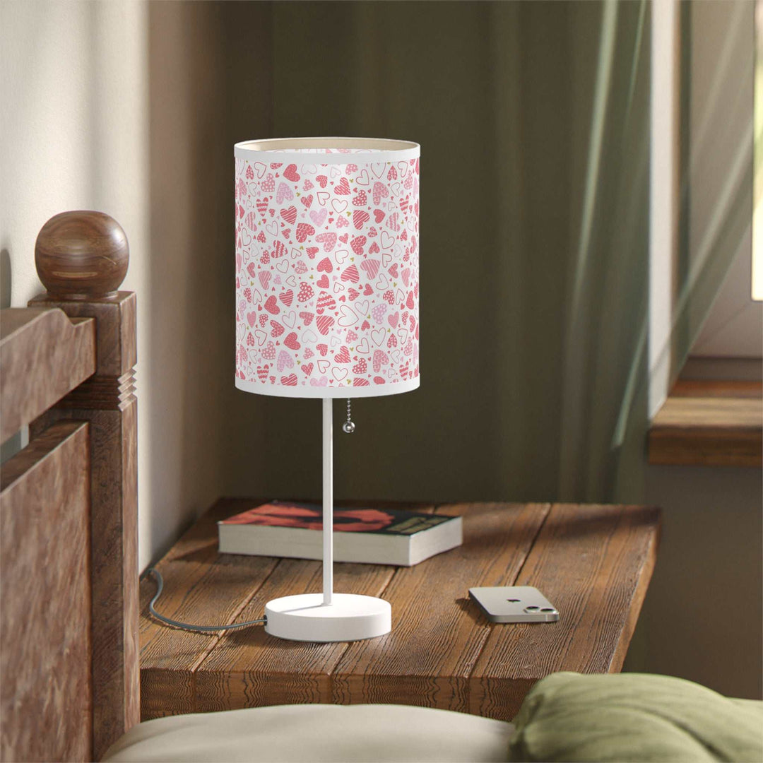 Hearts pattern lamp with white steel base and pink high-resolution printed shade on wooden bedside table