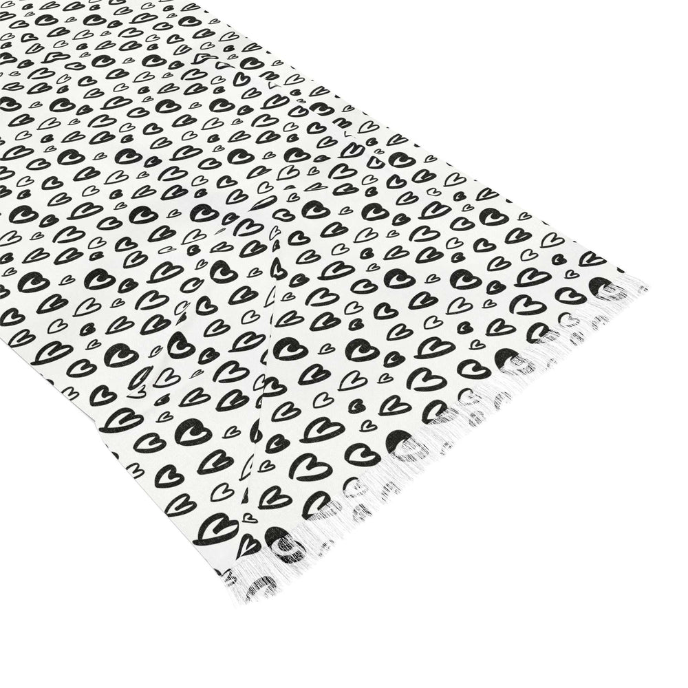 Lightweight white scarf with black heart pattern and fringed edges, made of transparent polyester fabric