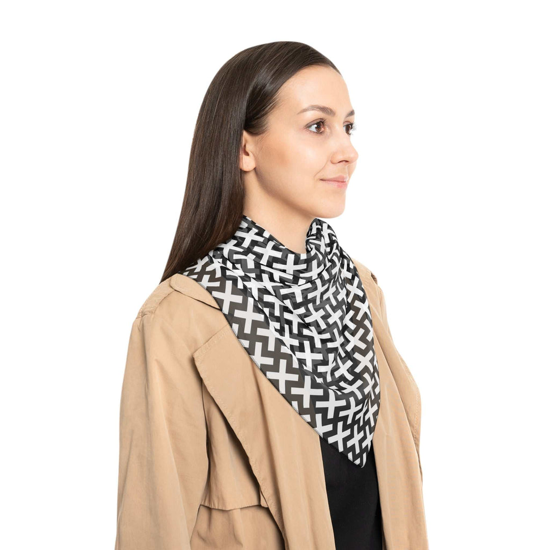 Woman wearing a sheer black and white Christian Cross poly scarf with black stitching, styled with a beige jacket and black top