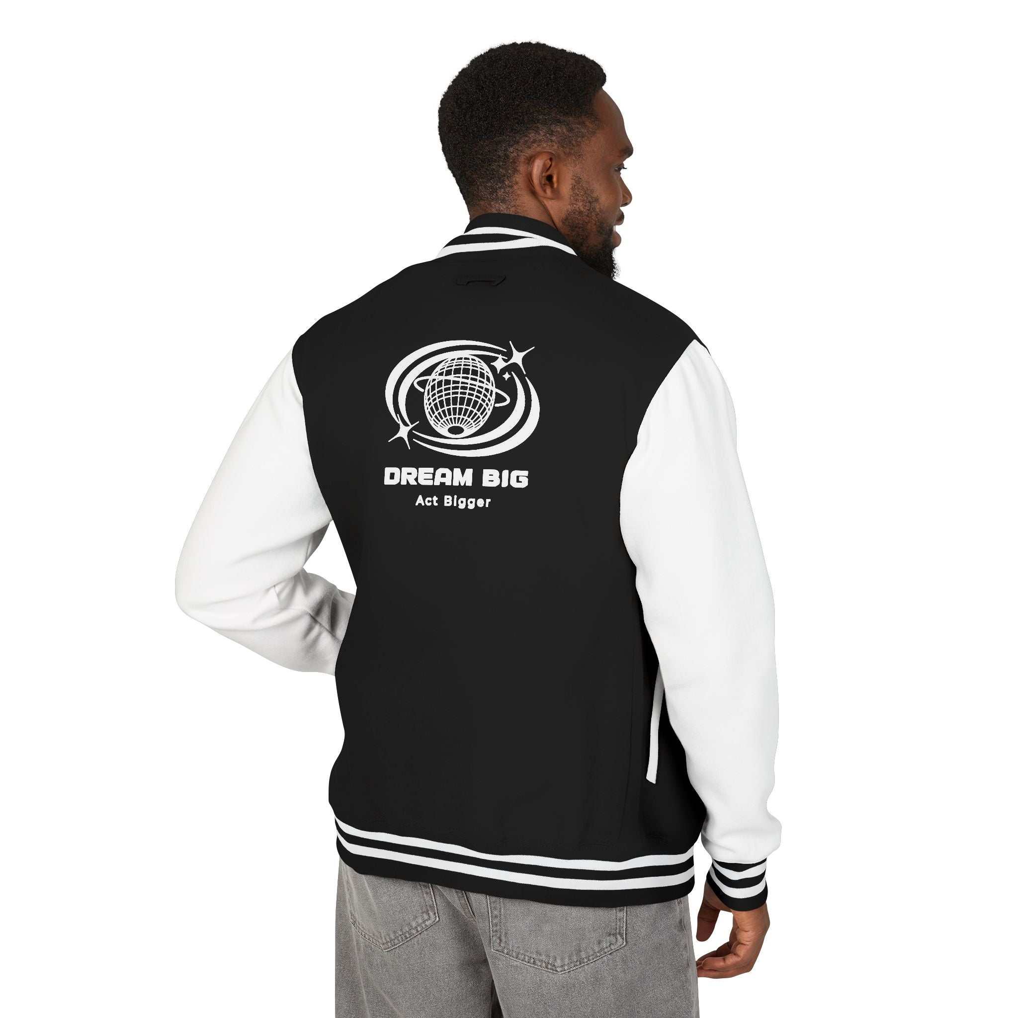 Man wearing black and white Dream Big varsity jacket with "Dream Big Act Bigger" logo on back