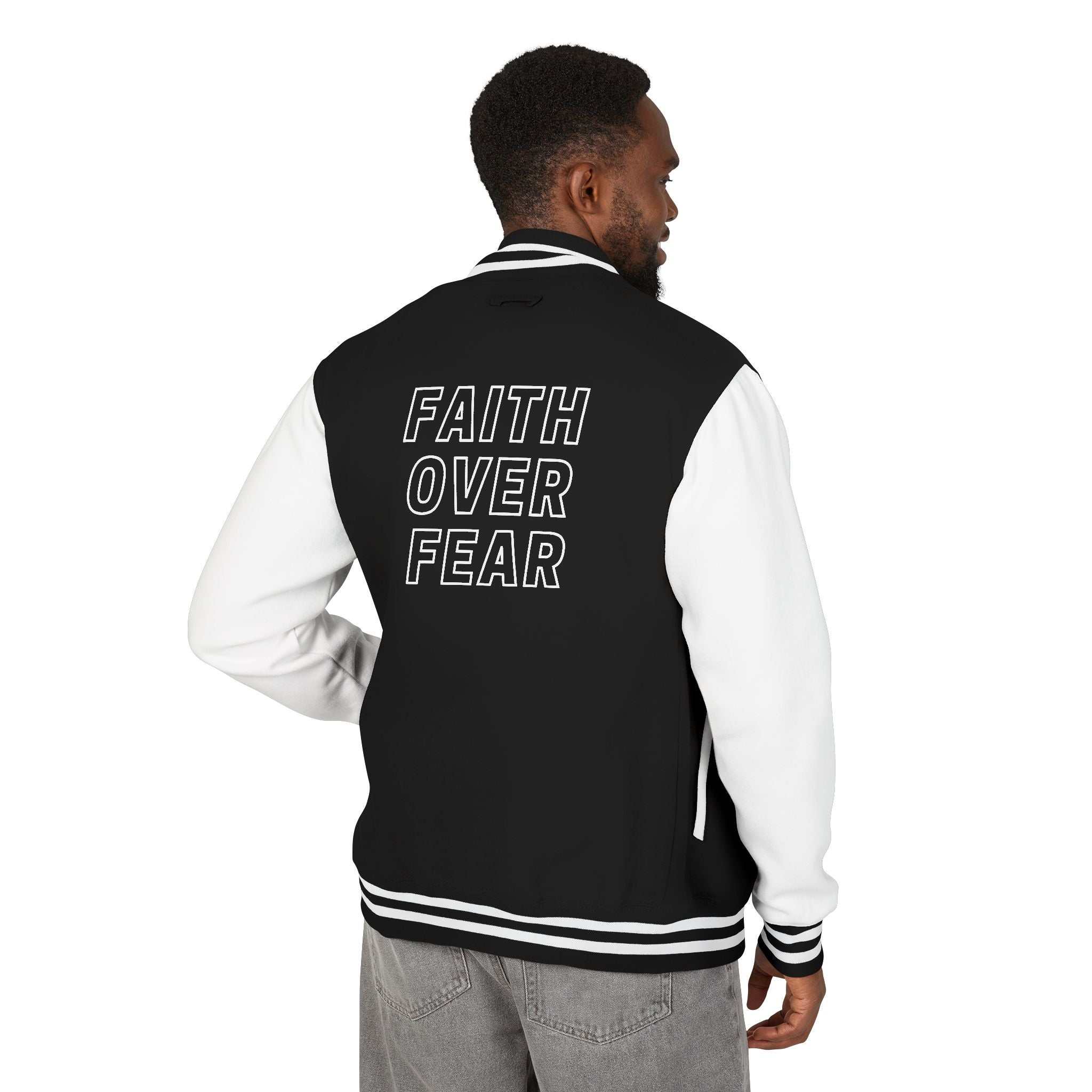 Man wearing black and white Faith Over Fear jacket with block text on back, casual style jacket