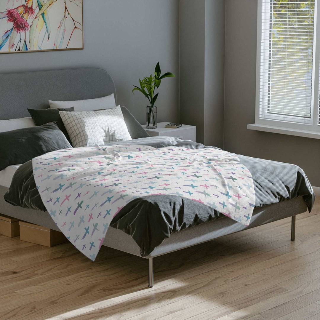 Soft fleece Christian Cross Blanket with pastel cross pattern draped on modern bed in bright bedroom