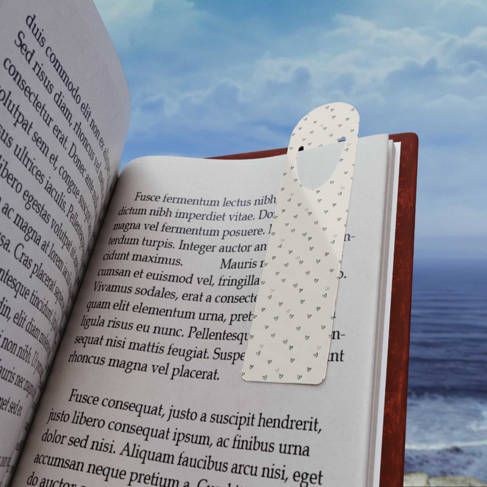 Love Pattern Bookmark aluminum page holder with small heart designs in a book against ocean background