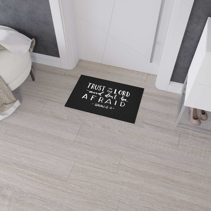 Black Bible Verse Floor Mat with Isaiah 12:2 quote and non-slip backing on light wooden floor