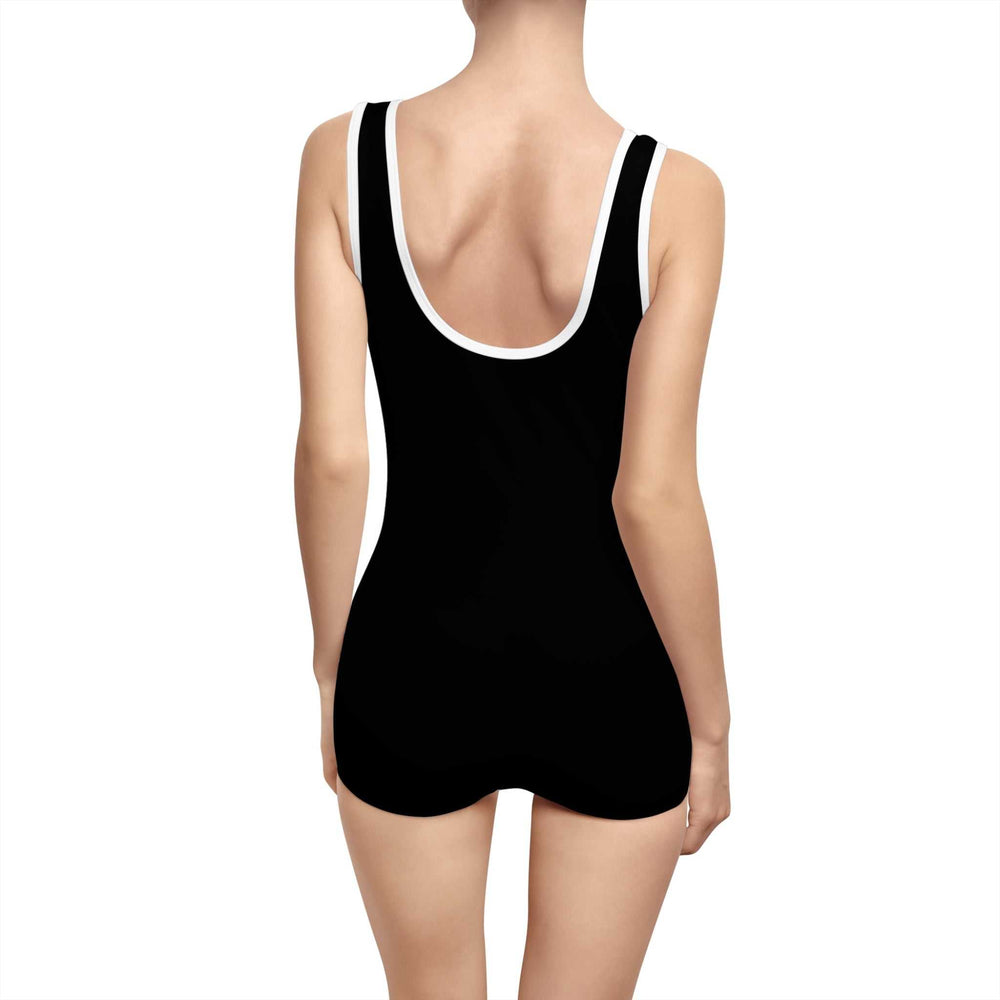 Back view of a woman wearing a black Choose Joy Vintage Swimsuit with deep U-back and white edging.
