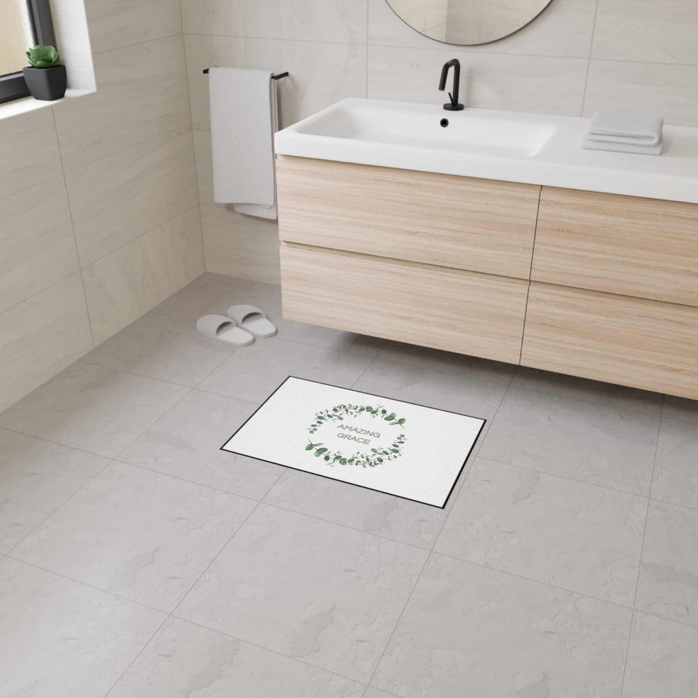 Amazing Grace Floor Mat with green leaf wreath design, black trim, non-slip backing in modern bathroom