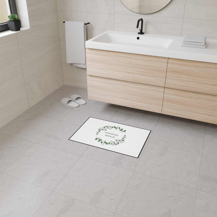 Amazing Grace Floor Mat with green leaf wreath design, black trim, non-slip backing in modern bathroom