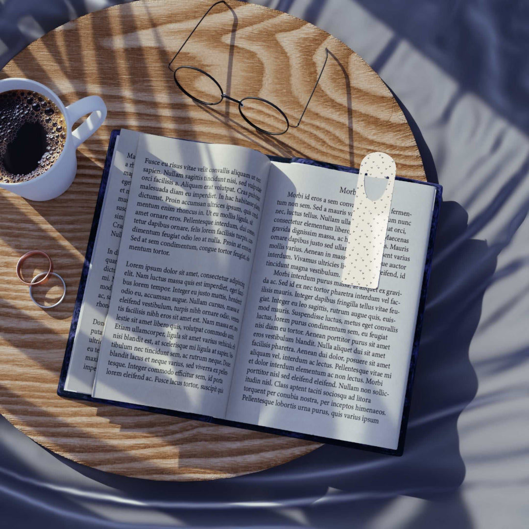 Open book with Love Pattern Bookmark on wooden table next to coffee and glasses