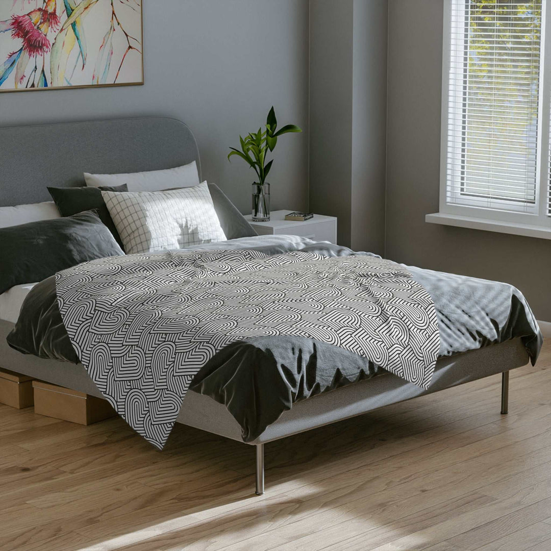 Cozy fleece blanket with black and white geometric heart pattern on modern bed in bright bedroom