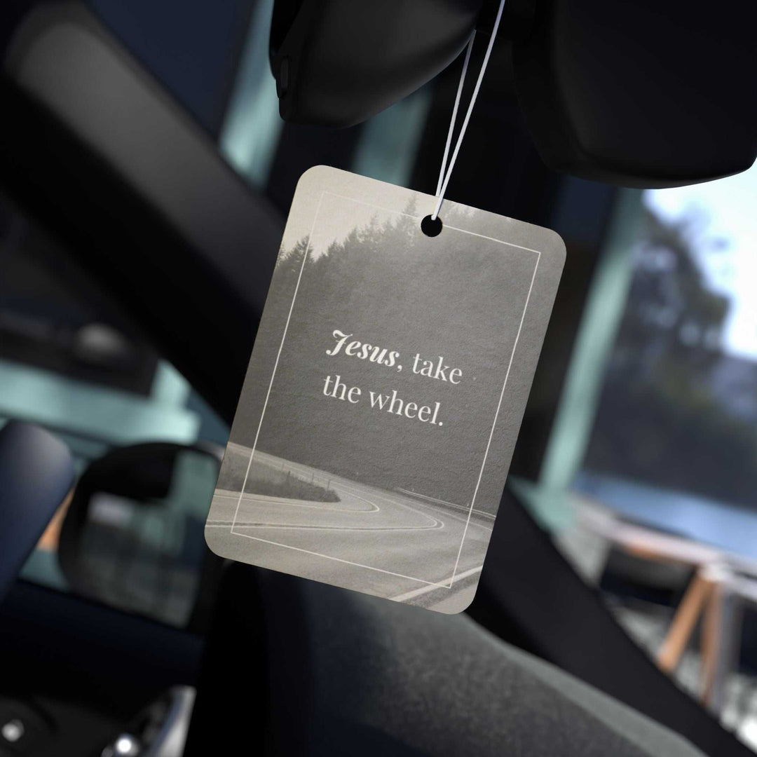 Guided by Jesus car air freshener with "Jesus, take the wheel" text hanging inside a car