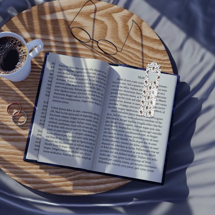 Christian pattern aluminum bookmark clipped to open book on wooden table with coffee and glasses nearby