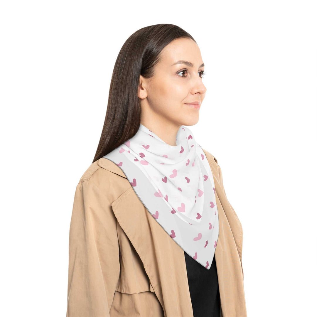 Woman wearing sheer pink hearts poly scarf with black stitching and beige jacket