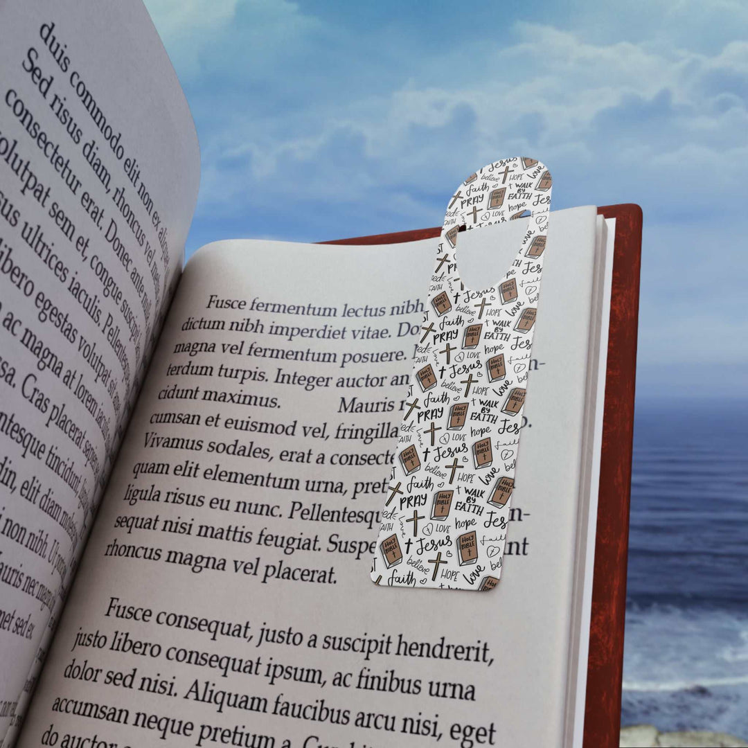 Christian Pattern Bookmark with faith-themed words and symbols placed inside an open book against a seaside background
