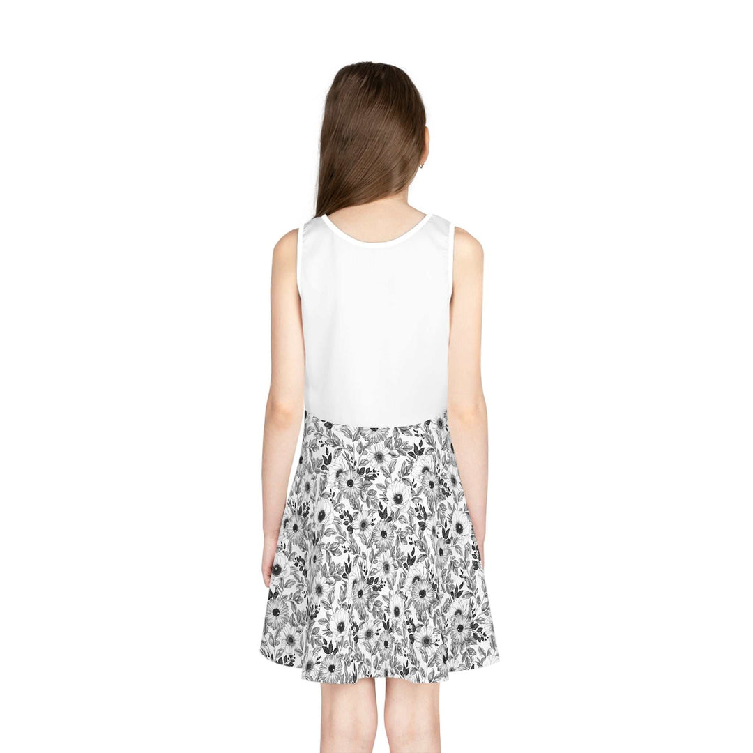 Back view of a sleeveless sundress with a white top and a black and white floral A-line skirt on a girl