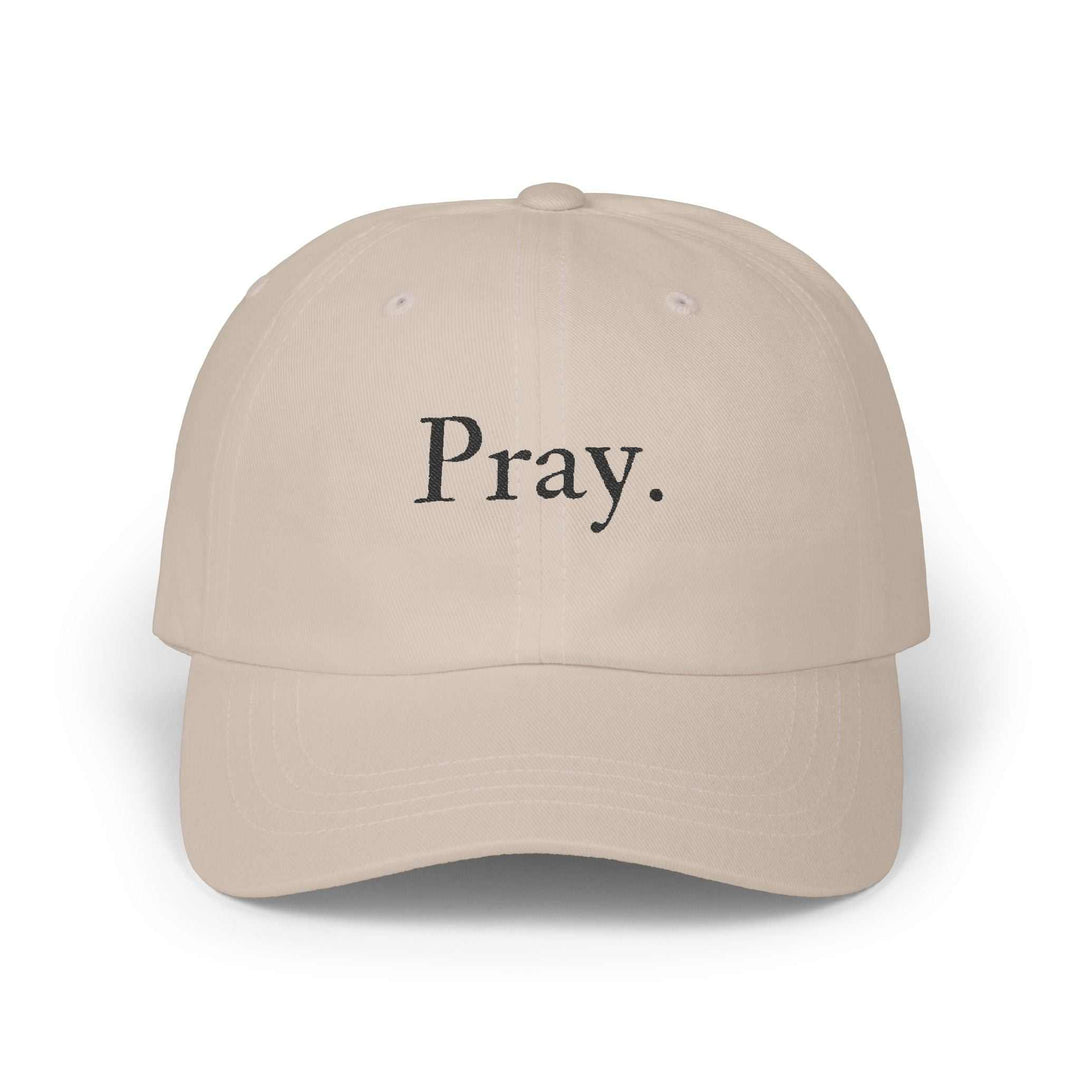 Beige cotton cap with "Pray." embroidered on front and adjustable strap closure