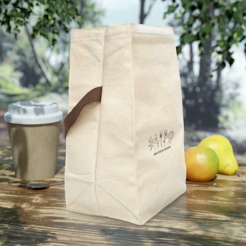 Beige canvas lunch bag with brown strap handle and roll closure