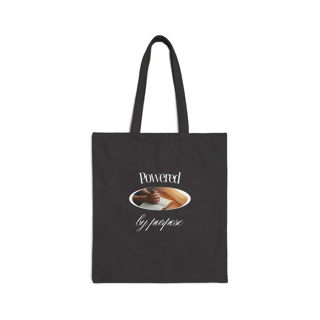 Black cotton canvas tote bag with "Powered by purpose" text and fist bump graphic