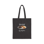 Black cotton canvas tote bag with "Powered by purpose" text and clasped hands design, eco-friendly and durable.