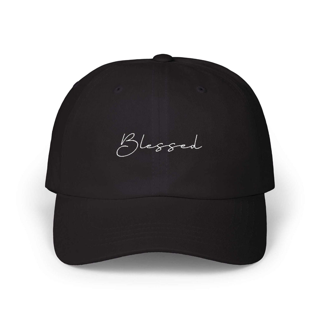 Black classic cap with "Blessed" embroidered in white script on the front, adjustable strap with antique brass buckle.