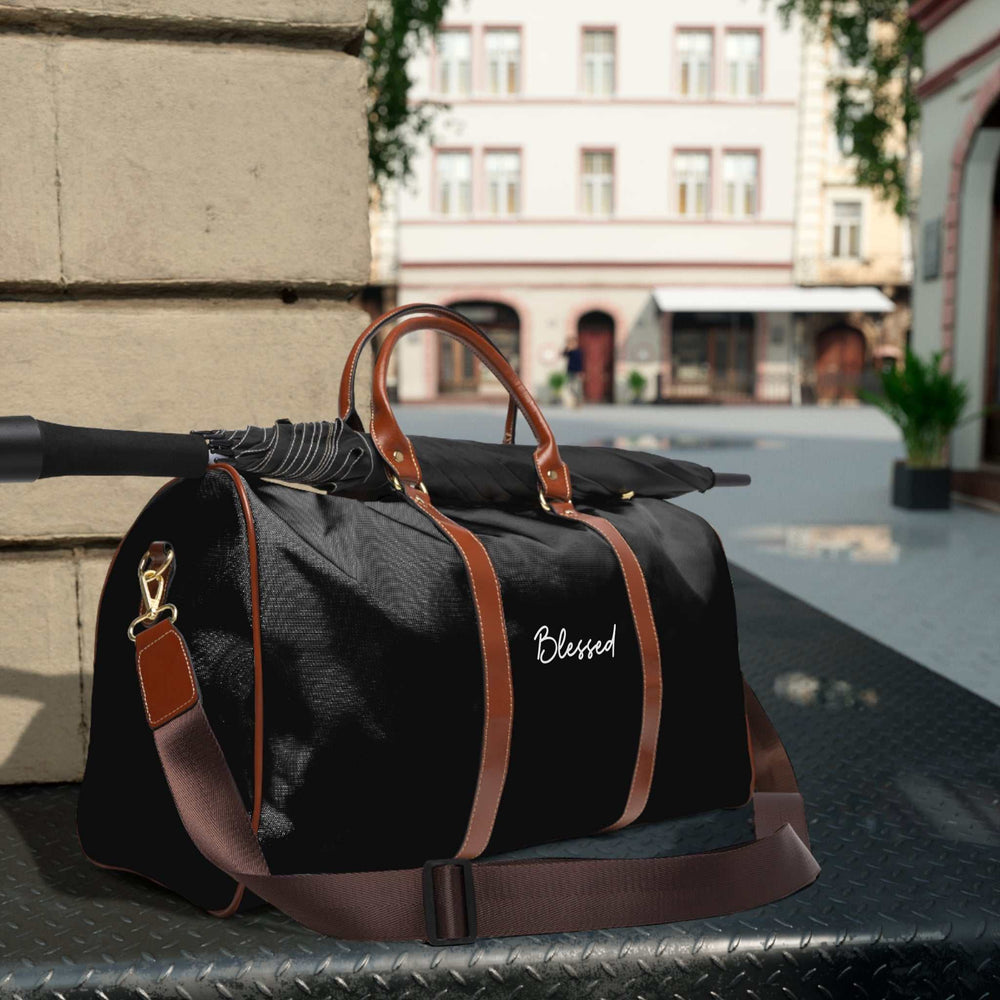 Black Blessed travel bag with brown PU leather handles and adjustable shoulder strap on city street background