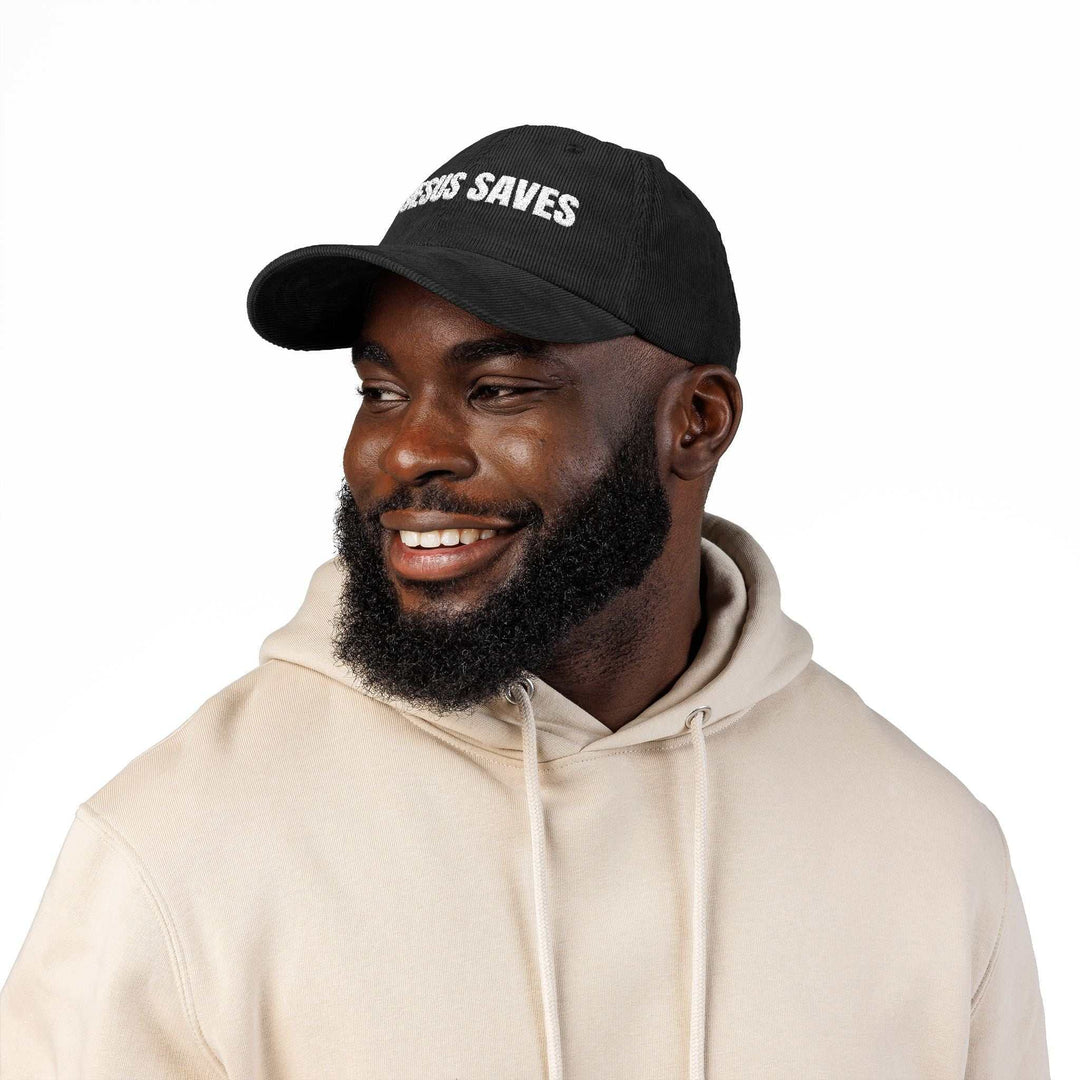 Black Jesus Saves vintage cap with adjustable strap worn by smiling man in beige hoodie