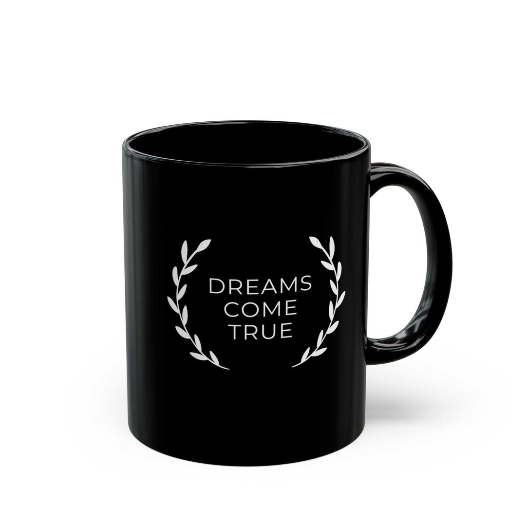 Black ceramic mug with "Dreams Come True" text and laurel wreath design, 11oz capacity, glossy finish, C-shaped handle.