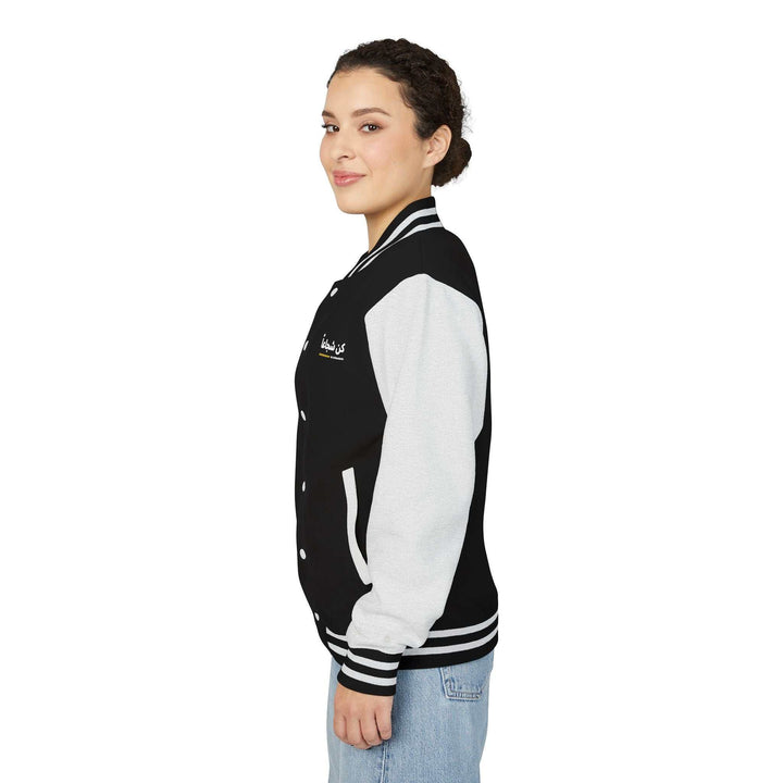 Woman wearing Be Courageous jacket with Arabic calligraphy and black and white color blocking.