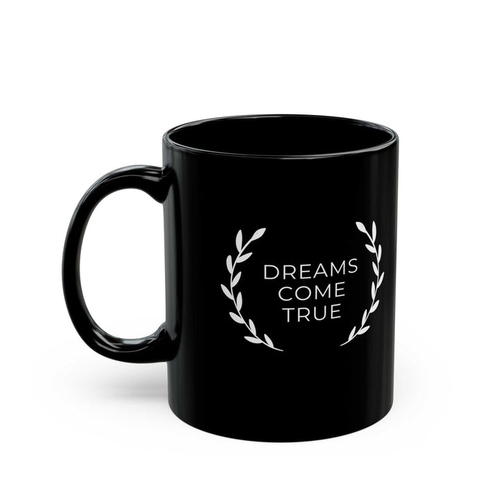 Black ceramic mug with "Dreams Come True" text and leaf design, 11oz, glossy finish, microwave and dishwasher safe.