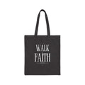 Black cotton canvas tote bag with "Walk by Faith" text design, durable and eco-friendly material.