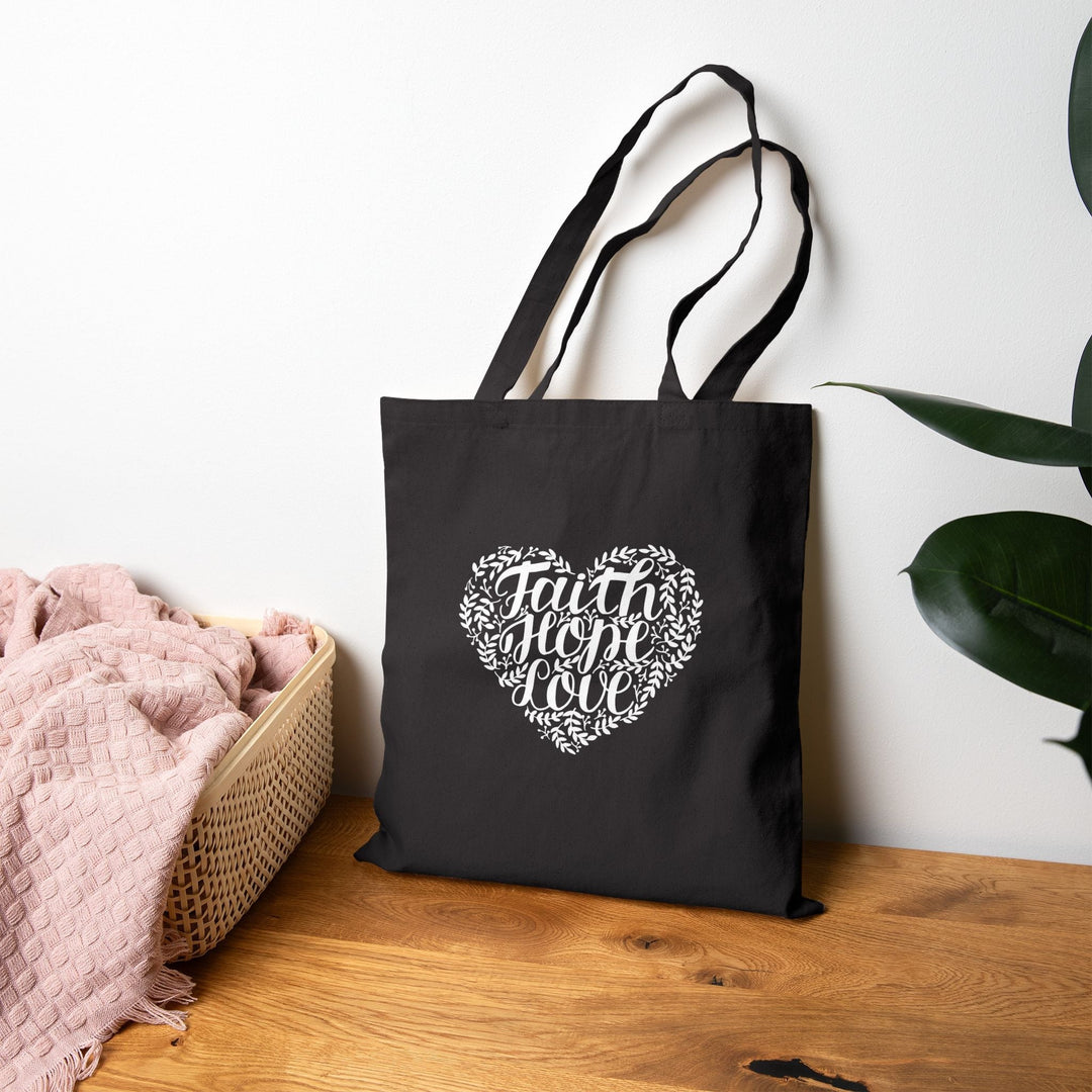 Black inspirational tote bag with "Faith Hope Love" heart design