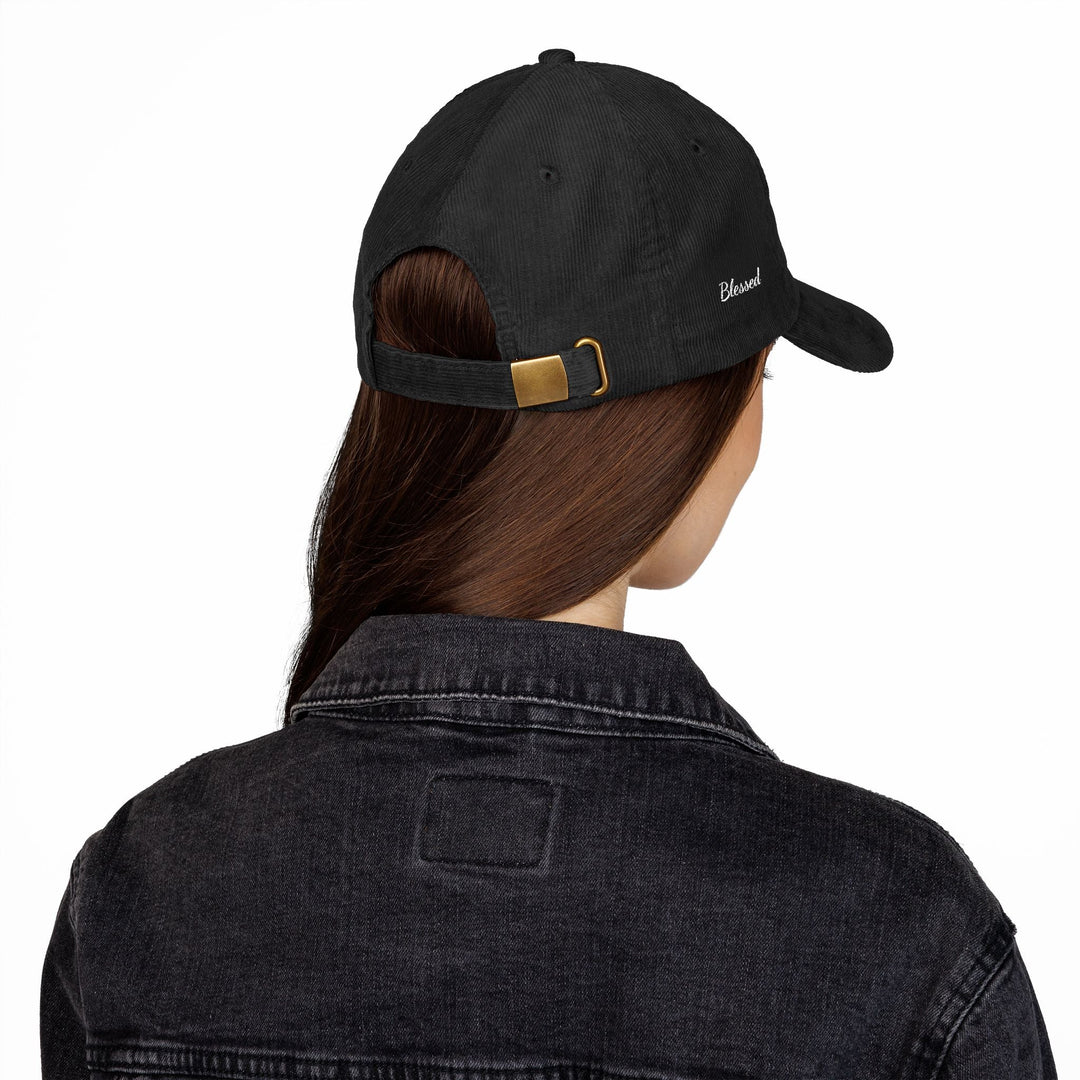 Black vintage corduroy cap with adjustable gold buckle strap worn