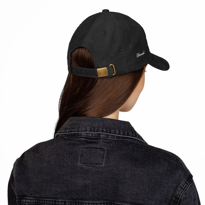 Black vintage corduroy cap with adjustable gold buckle strap worn