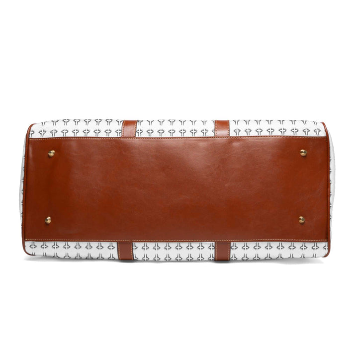 Bottom view of Christian Cross travel bag with brown PU leather base and gold-colored studs on white patterned nylon material