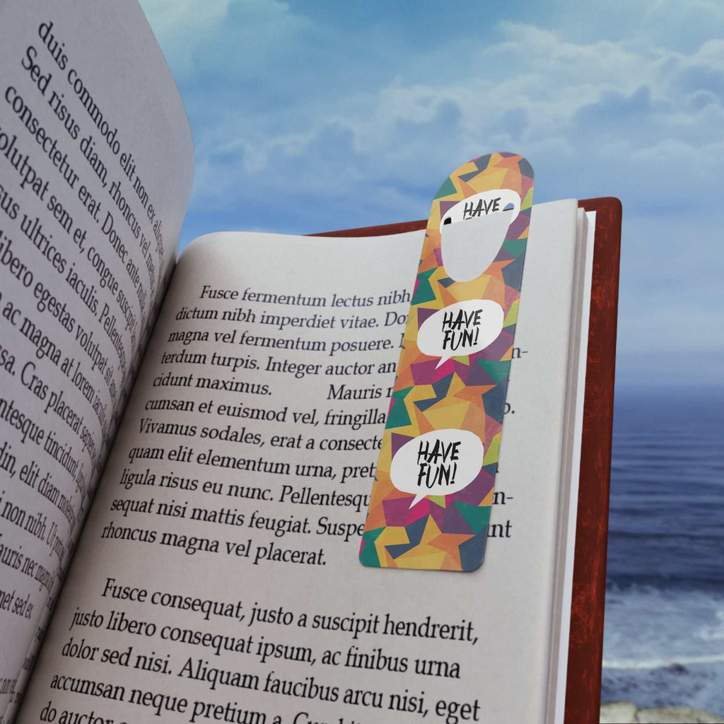 Colorful Have Fun Bookmark clipped inside an open book by the sea