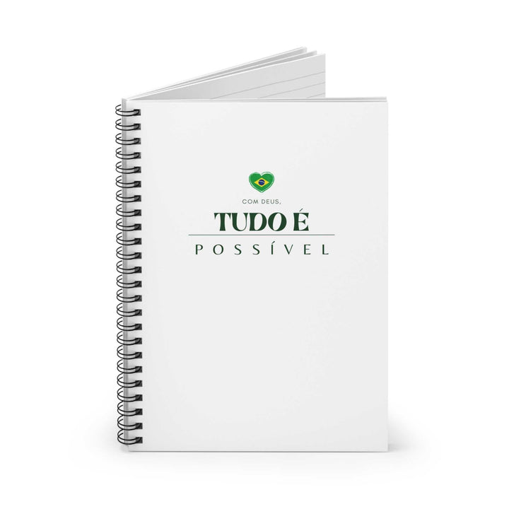 Spiral-bound notebook with white cover featuring green text "Com Deus, Tudo é Possível" and a small heart-shaped Brazilian flag design