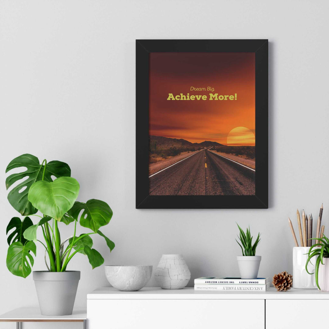 Framed Dream Big poster with a motivational road and sunset design hanging above a white sideboard with plants and decor items