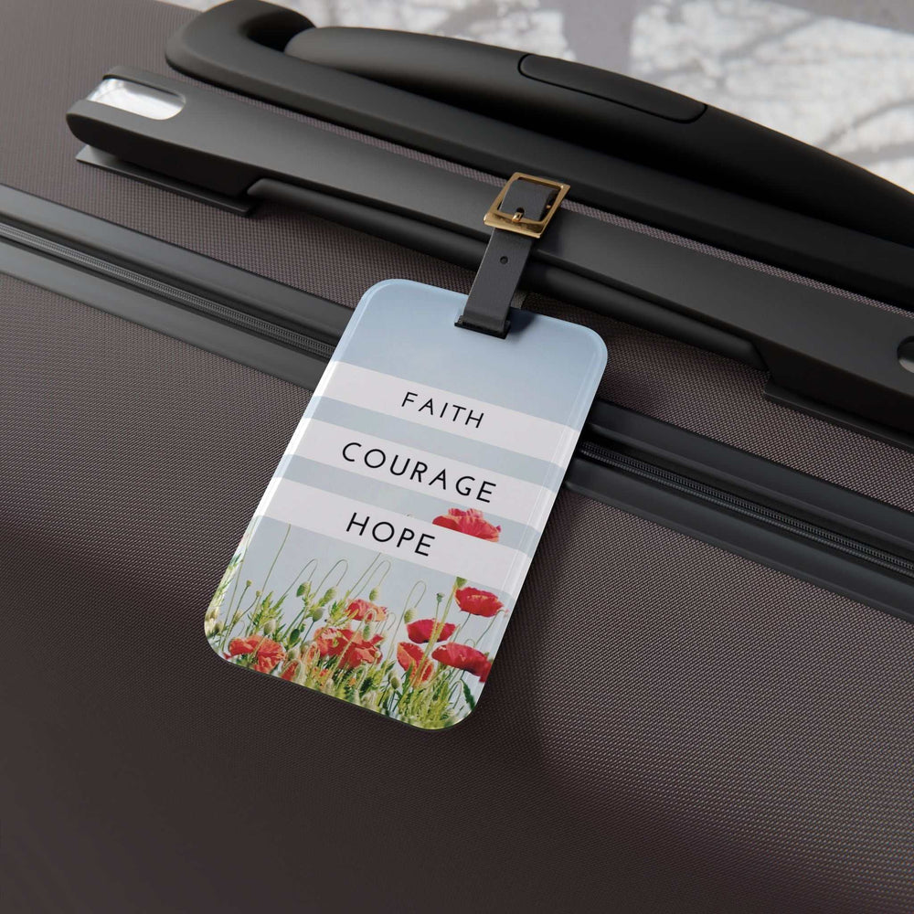 Faith Courage Hope luggage tag with floral design and adjustable leather strap attached to suitcase handle