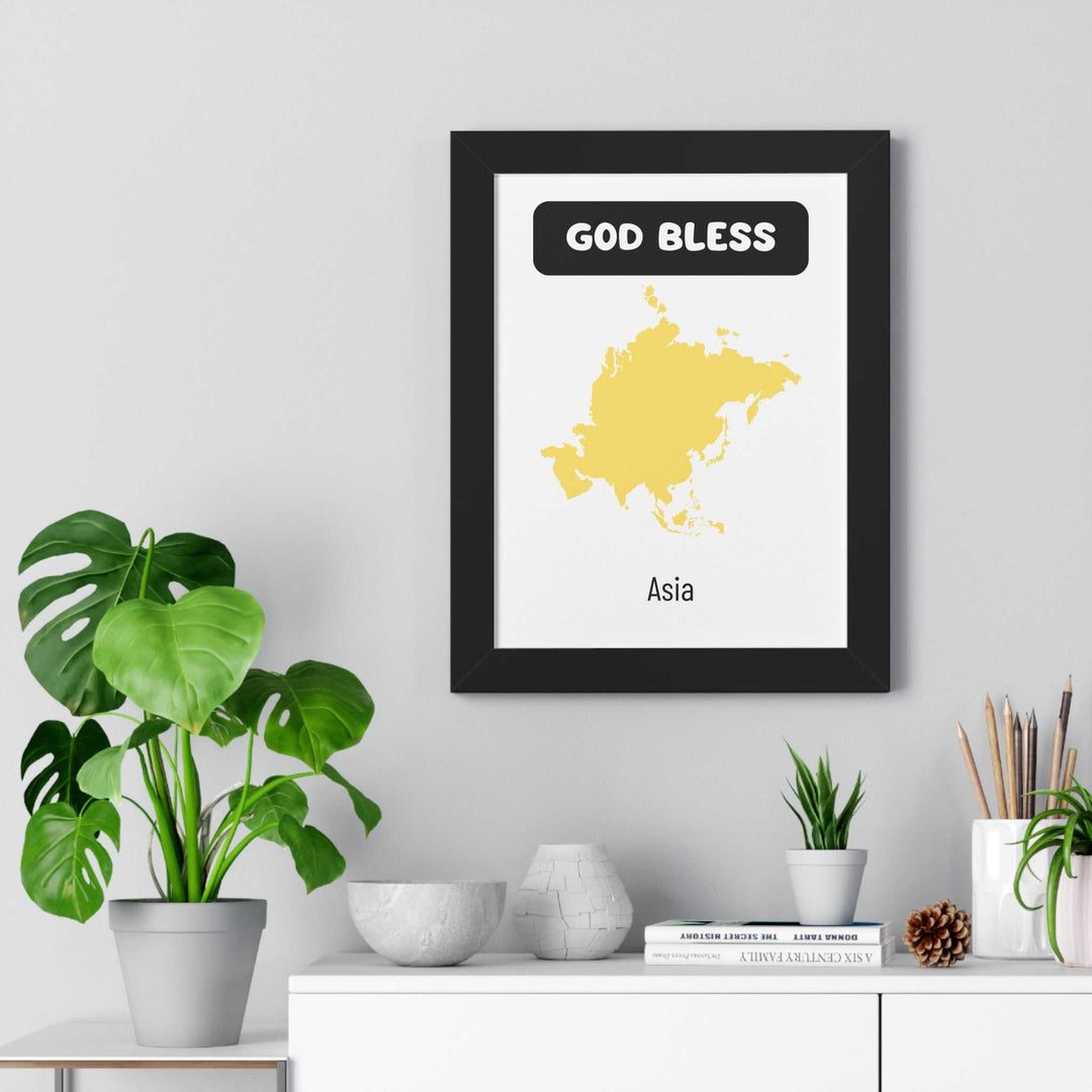 God Bless Asia poster with yellow map of Asia in black frame on wall above white shelf with plants and decor