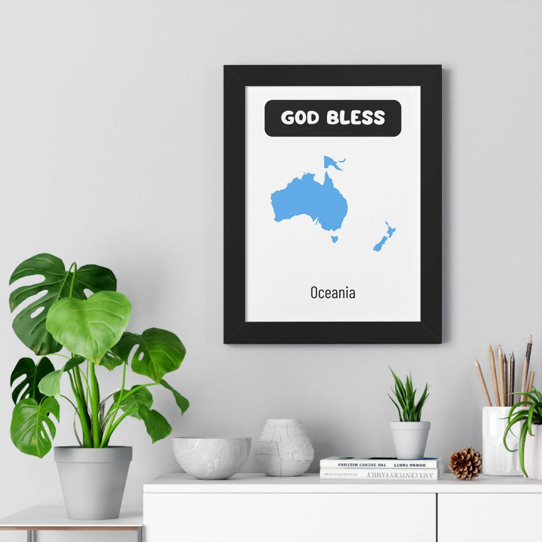 God Bless Oceania poster with blue map design in black frame on wall above white shelf with plants and decor