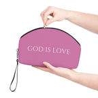 Pink God Is Love makeup bag with detachable strap and curved shape held by hands