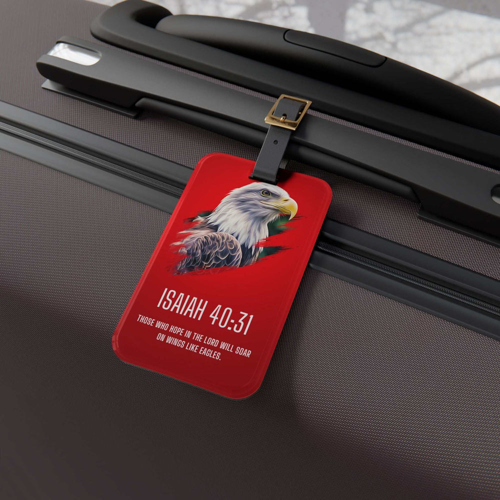 Red Isaiah 40:31 luggage tag with eagle illustration and inspirational Bible verse attached to dark suitcase handle