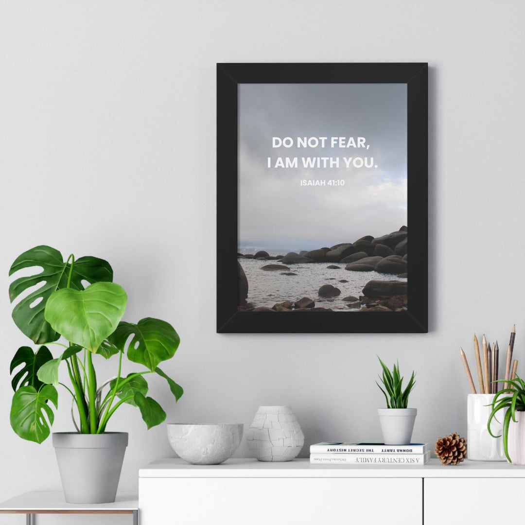 Isaiah 41:10 inspirational poster with calming coastal background in black frame on wall above white shelf with plants and decor