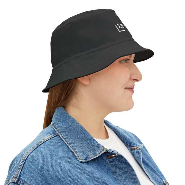 Black Jesus bucket hat in polyester worn by woman with denim jacket, stylish faith-inspired bucket hat