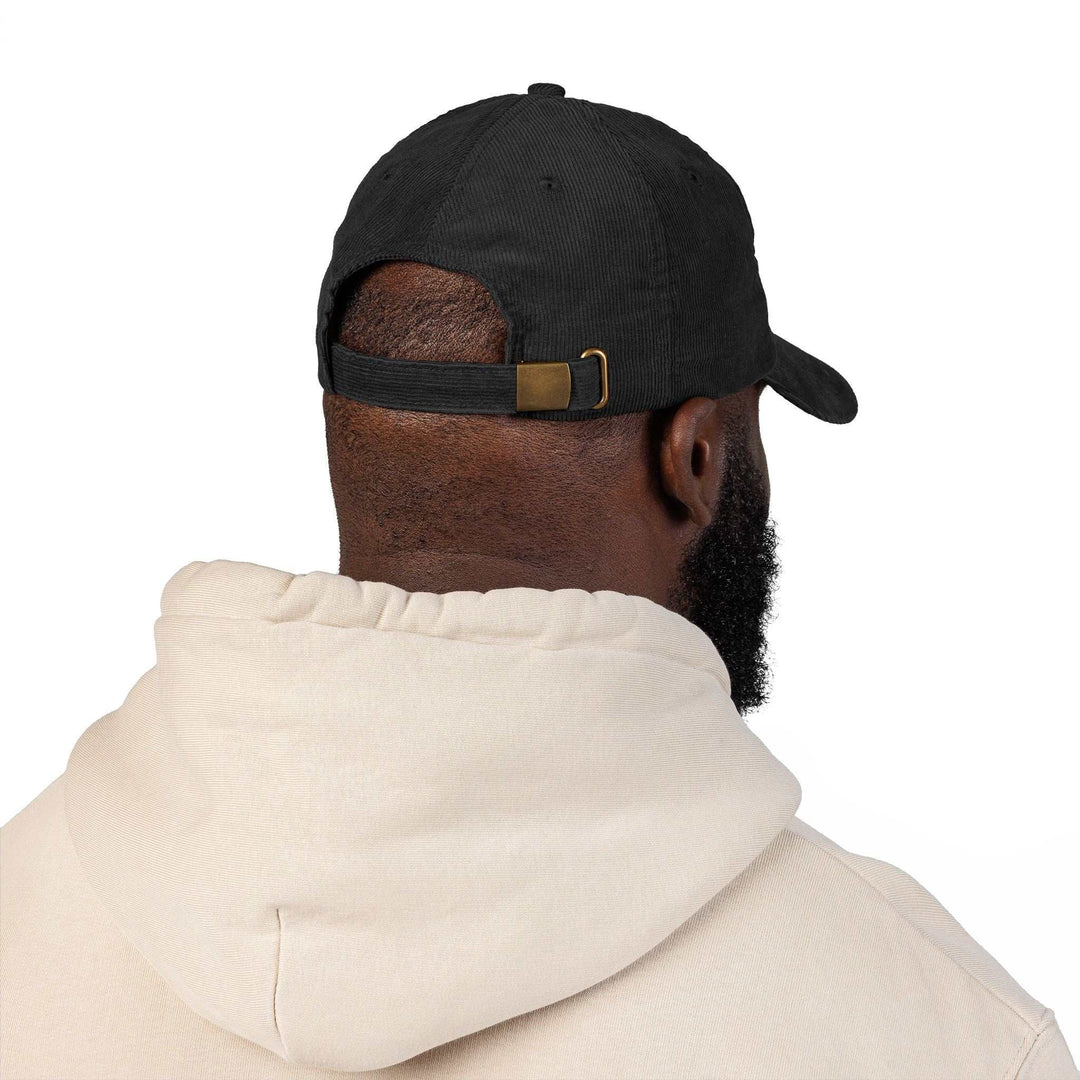 Black Jesus Saves vintage cap with adjustable strap and gold metal buckle shown from the back worn by a person in a beige hoodie