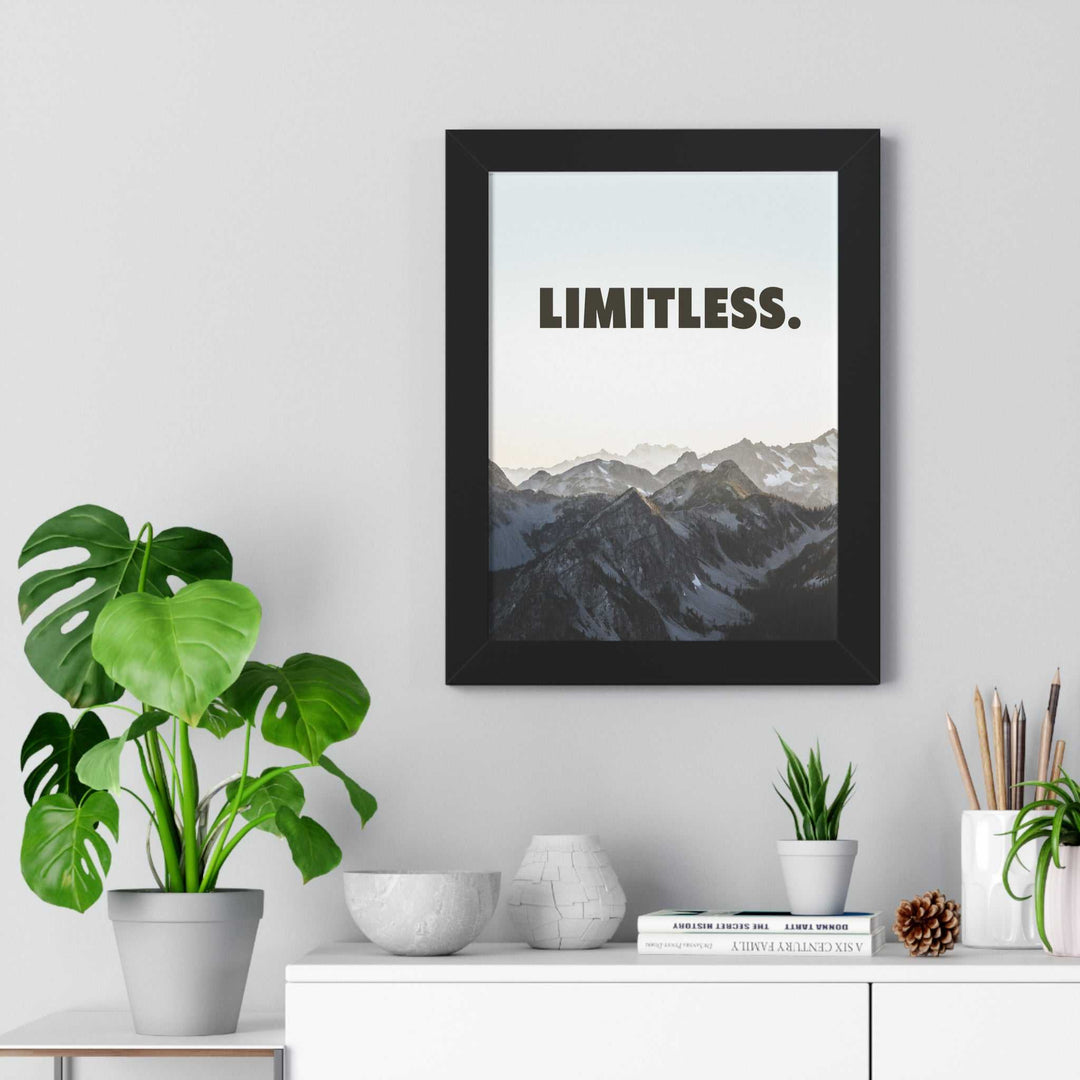 Limitless framed poster with mountain landscape and motivational text in black Ayous wood frame displayed on a wall above a white shelf with plants and decor.