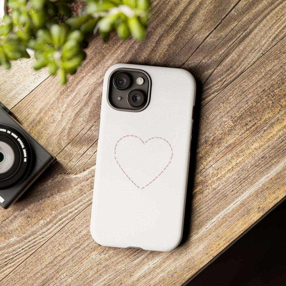 White Love Wins phone case with stitched heart design on wooden surface